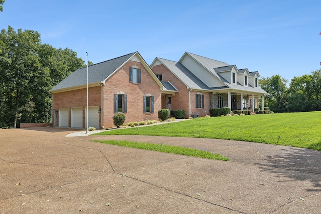 new england style home with a front lawn, a porch, and a garage