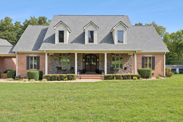 cape cod home featuring covered porch and a front lawn