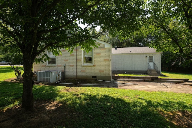 exterior space with cooling unit and a lawn