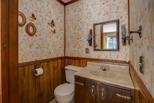 bathroom featuring wood walls, vanity, and toilet