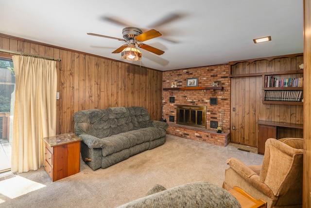 living room with ceiling fan, a fireplace, light carpet, and wood walls