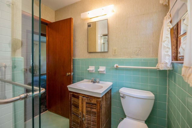 bathroom with tasteful backsplash, vanity, tile walls, and toilet