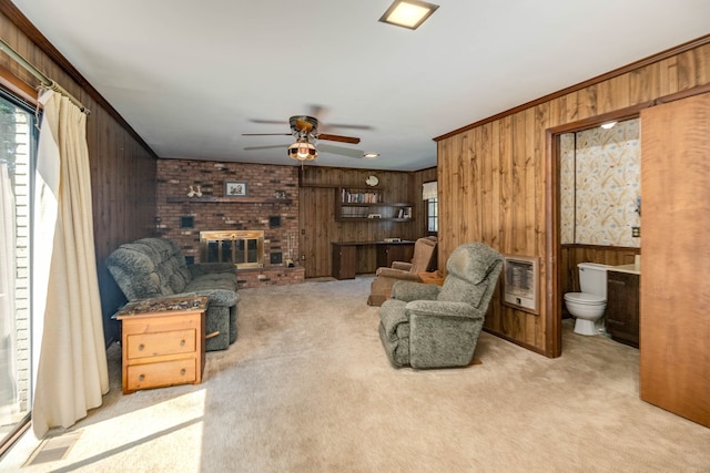 living room with ceiling fan, light carpet, wooden walls, and a brick fireplace