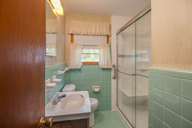 bathroom featuring a shower with shower door, toilet, tile patterned floors, tile walls, and vanity