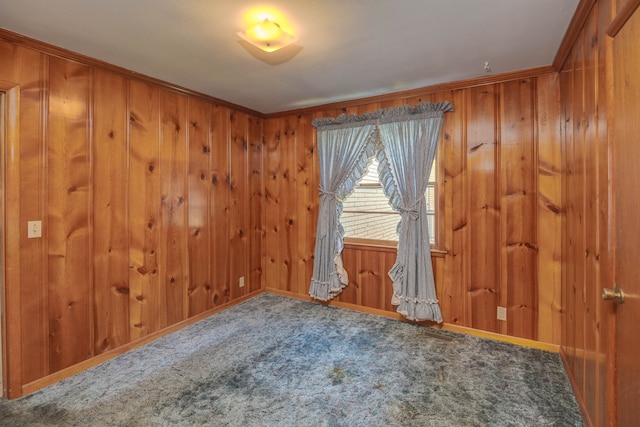 unfurnished room with wooden walls, ornamental molding, and carpet floors