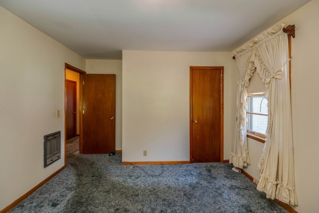 carpeted empty room featuring heating unit