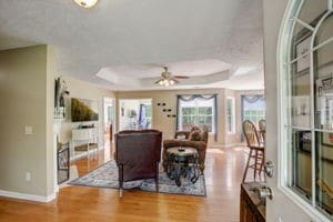 dining room with ceiling fan, a tray ceiling, and wood-type flooring