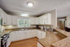 kitchen featuring light hardwood / wood-style flooring, sink, white cabinets, and stove