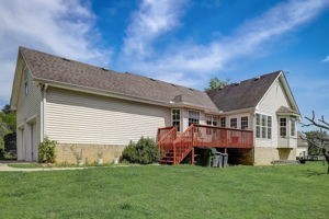 back of property featuring a yard and a deck