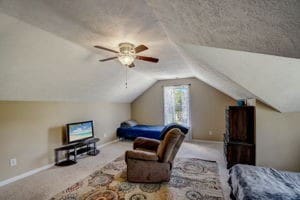 bedroom featuring ceiling fan, vaulted ceiling, and light carpet