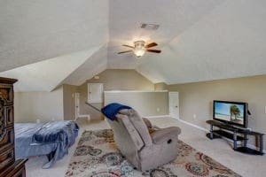 bedroom with ceiling fan, lofted ceiling, and light colored carpet