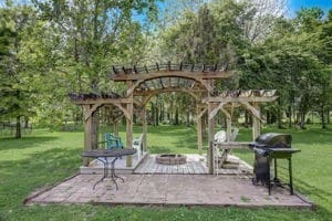 view of property's community with a lawn, a patio area, an outdoor fire pit, and a pergola