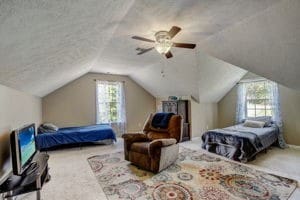 carpeted bedroom with lofted ceiling, a textured ceiling, and ceiling fan