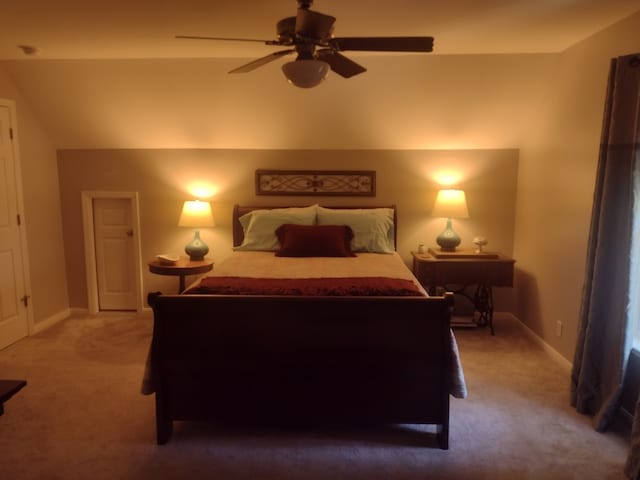 bedroom with ceiling fan, carpet flooring, and lofted ceiling