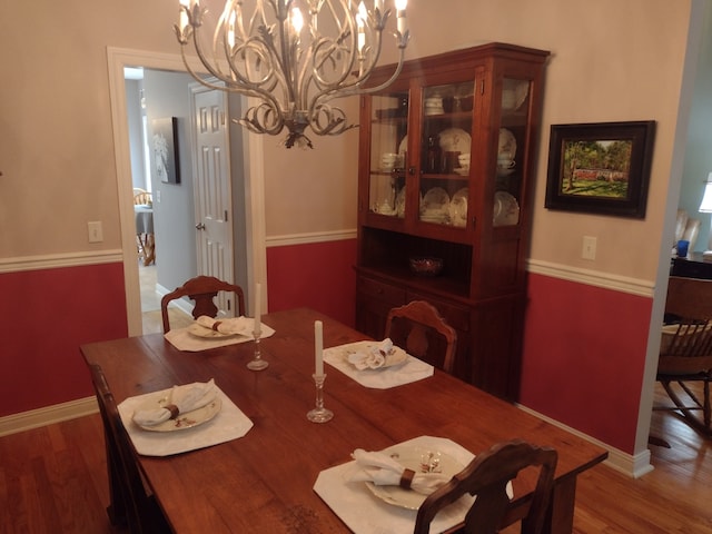 dining room featuring hardwood / wood-style floors and an inviting chandelier