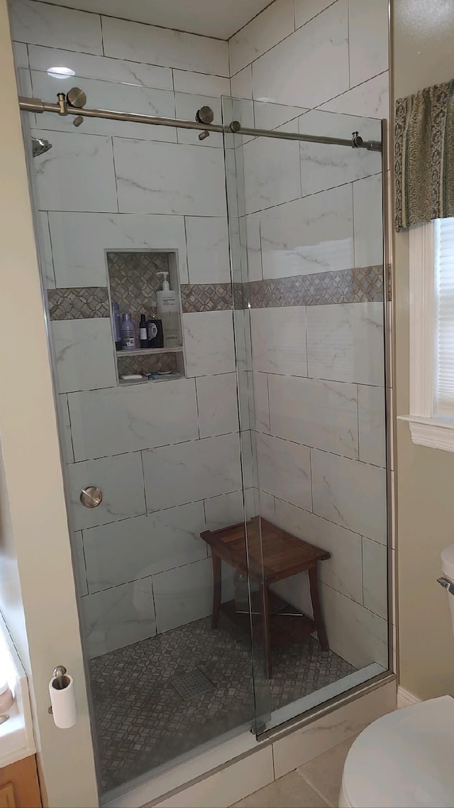 bathroom with toilet, tile patterned floors, and an enclosed shower