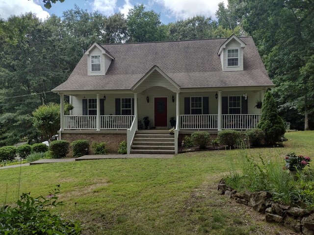 cape cod home featuring a porch and a front yard