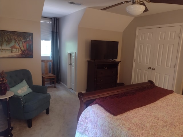 carpeted bedroom with ceiling fan, lofted ceiling, and a closet