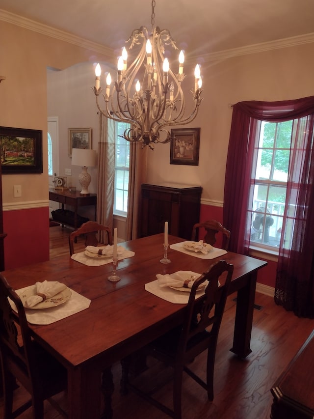 dining area with crown molding, hardwood / wood-style floors, and a chandelier