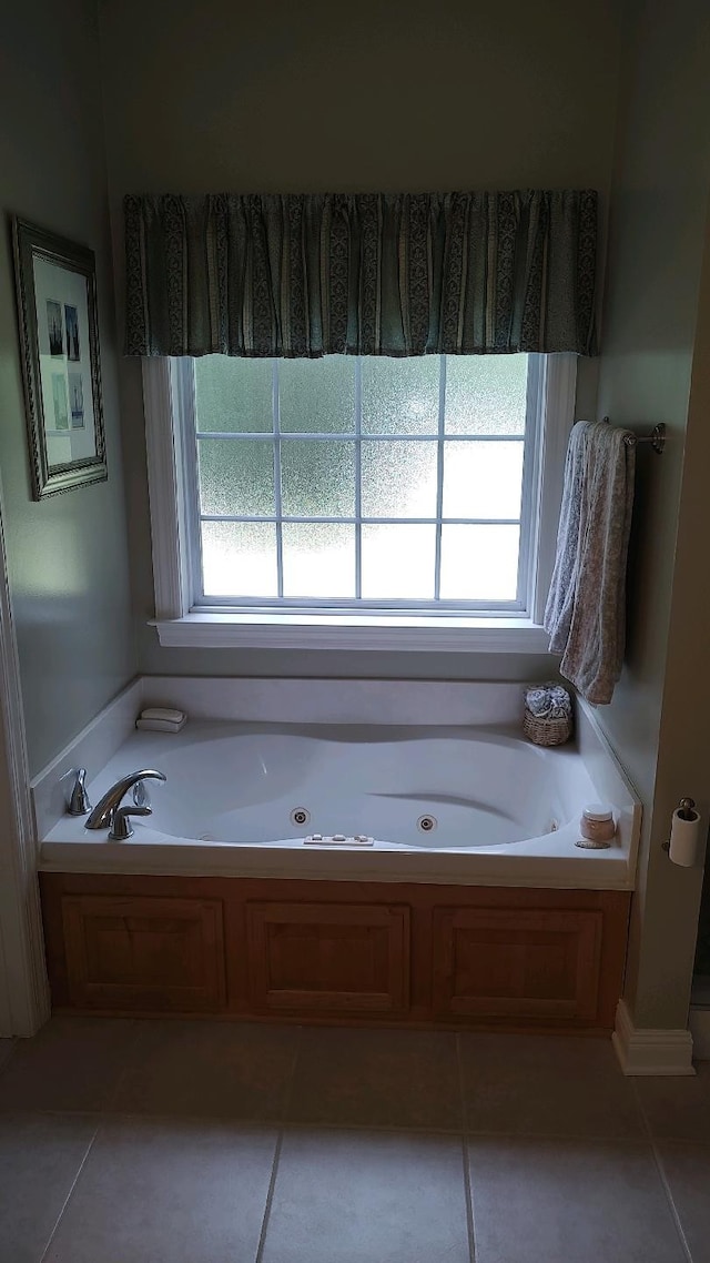 bathroom with a washtub, tile patterned floors, and a wealth of natural light