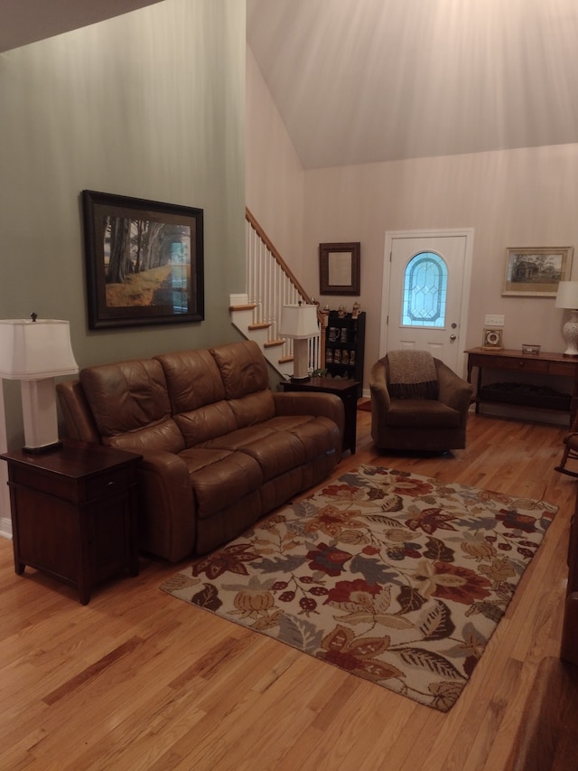 living room featuring high vaulted ceiling and light wood-type flooring