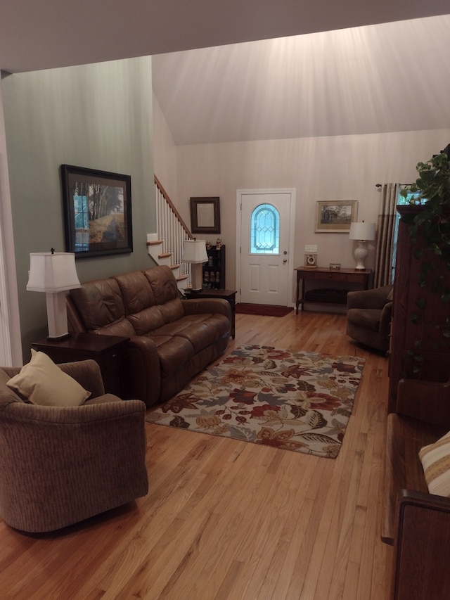 living room featuring lofted ceiling and hardwood / wood-style flooring