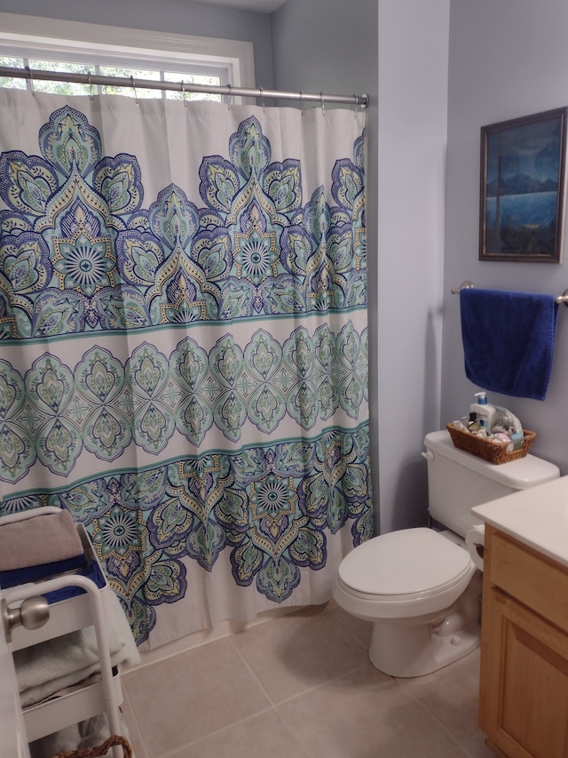 bathroom featuring toilet, tile patterned floors, vanity, and plenty of natural light