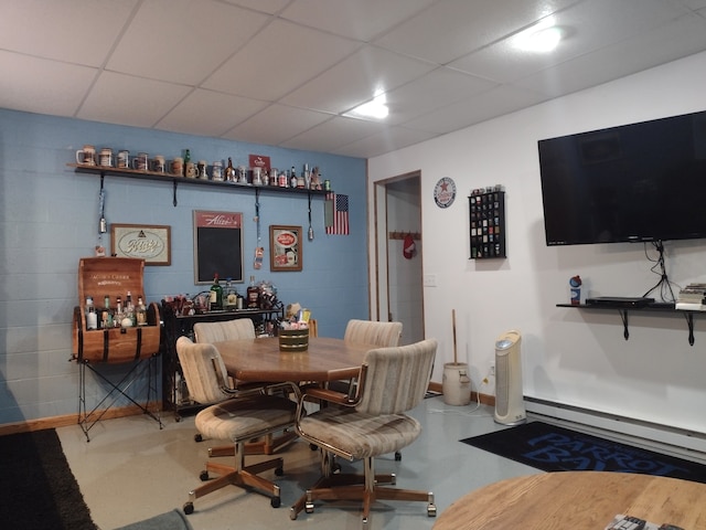 dining room featuring a baseboard heating unit and a paneled ceiling