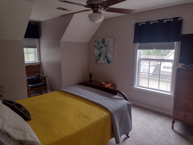 bedroom with ceiling fan, vaulted ceiling, and carpet floors