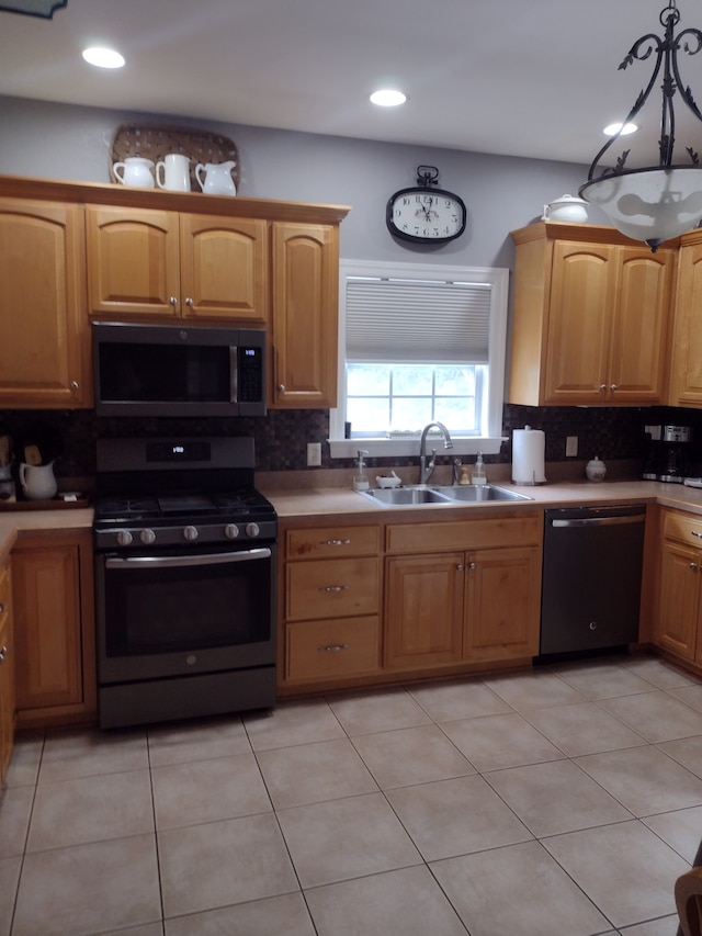 kitchen featuring hanging light fixtures, backsplash, black dishwasher, and range with gas stovetop