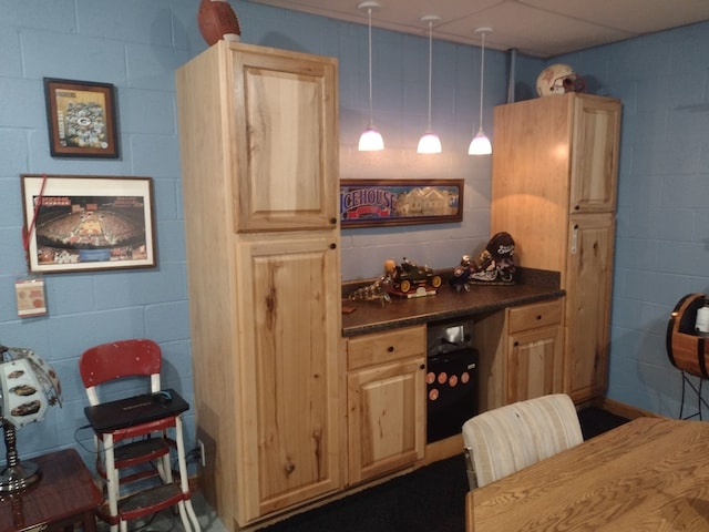 kitchen featuring light brown cabinets and decorative light fixtures