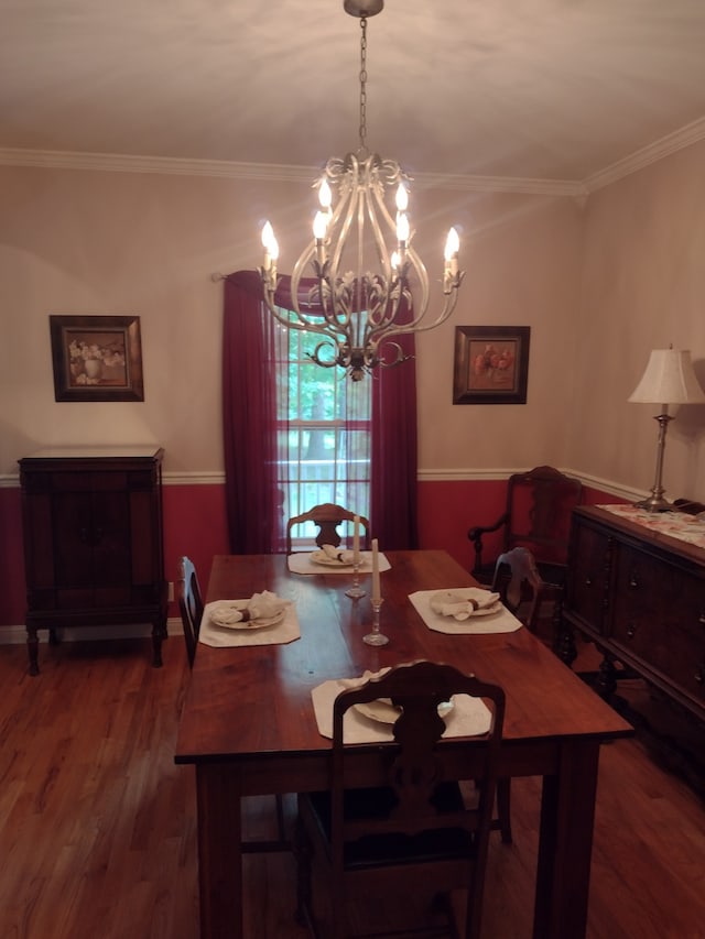 dining space with a notable chandelier, crown molding, and hardwood / wood-style floors