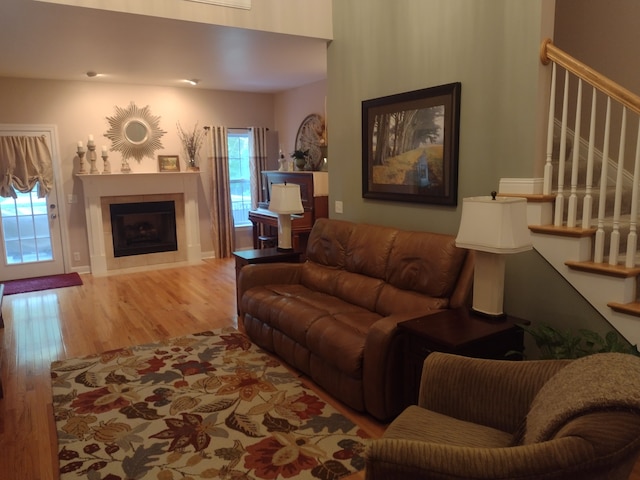 living room with a tile fireplace and hardwood / wood-style flooring