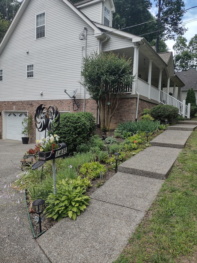 view of property exterior with a porch and a garage