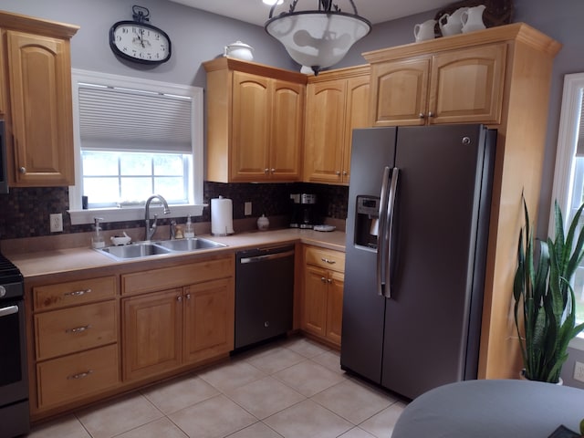 kitchen with tasteful backsplash, black appliances, sink, and light tile patterned floors