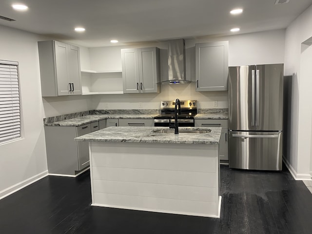 kitchen featuring light stone countertops, an island with sink, stainless steel appliances, and wall chimney range hood