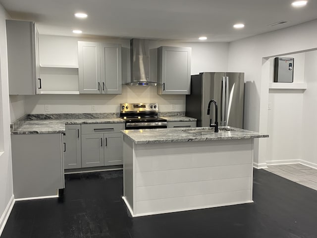 kitchen with wall chimney exhaust hood, sink, stainless steel appliances, and a kitchen island with sink