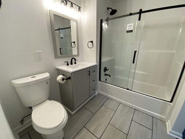 full bathroom with vanity, toilet, and enclosed tub / shower combo