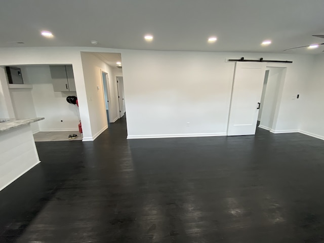 spare room with a barn door and dark hardwood / wood-style flooring