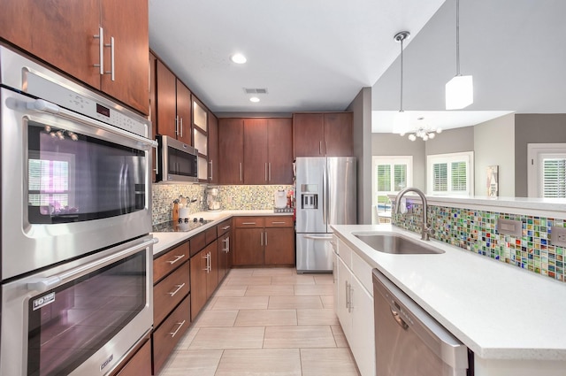 588 E Church St, Alamo, TN 38001 - kitchen with stainless steel appliances, a sink, light countertops, backsplash, and pendant lighting