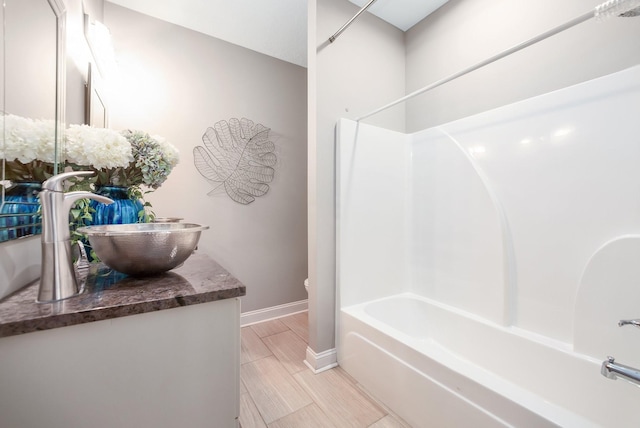 588 E Church St, Alamo, TN 38001 - bathroom with wood finish floors, bathtub / shower combination, toilet, vanity, and baseboards