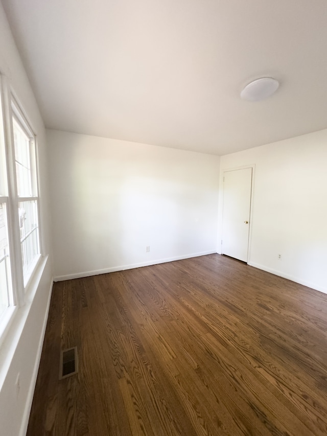 empty room with dark hardwood / wood-style flooring