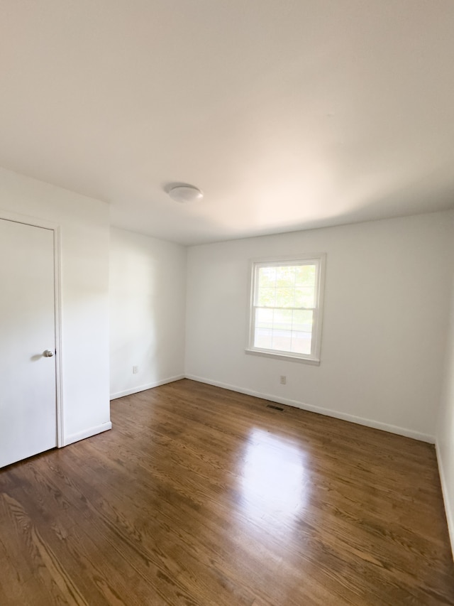 spare room with dark hardwood / wood-style floors