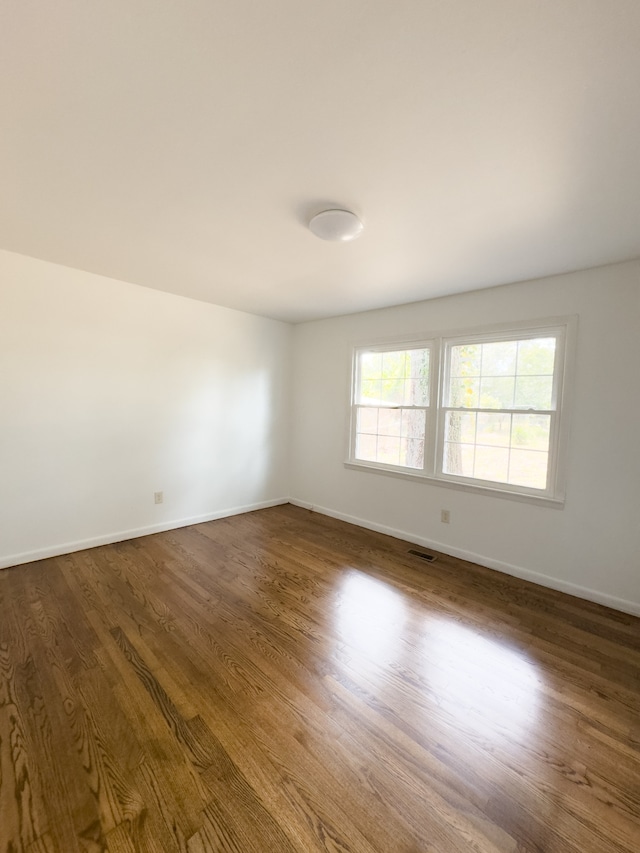 unfurnished room with dark hardwood / wood-style floors