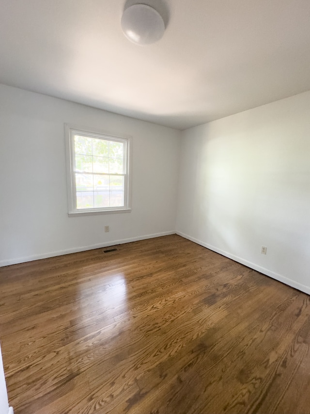 unfurnished room with hardwood / wood-style floors