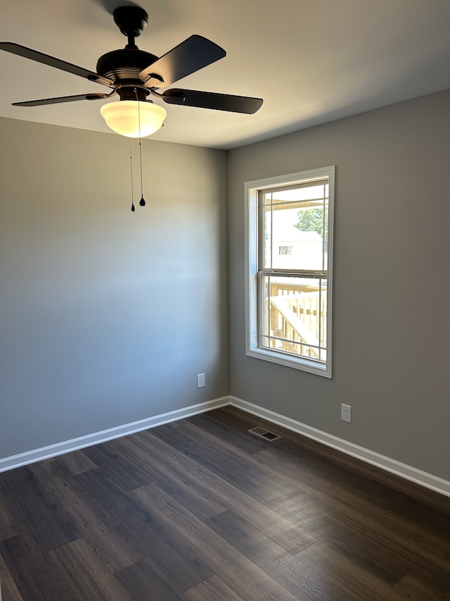 spare room with dark hardwood / wood-style floors and ceiling fan