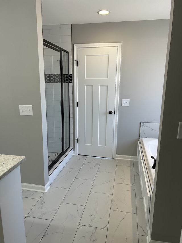 bathroom featuring vanity and independent shower and bath