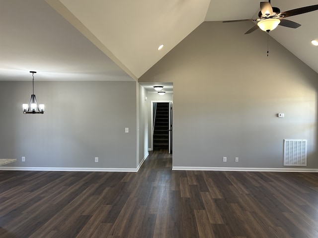 interior space featuring dark hardwood / wood-style flooring, ceiling fan with notable chandelier, and vaulted ceiling