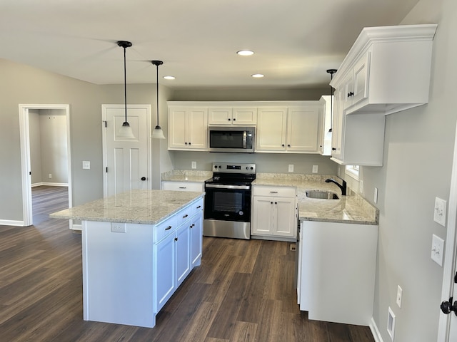 kitchen featuring white cabinets, sink, decorative light fixtures, a kitchen island, and stainless steel appliances