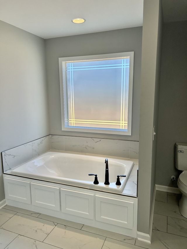 bathroom with a washtub and toilet